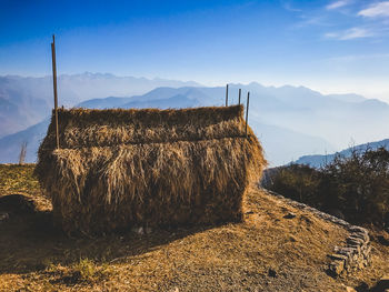 Panoramic shot of hay bales on field against sky