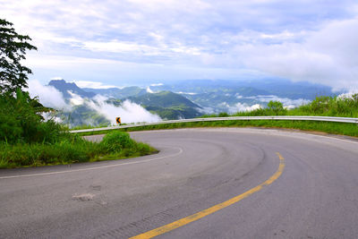 Road by mountains against sky