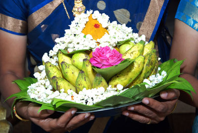 Midsection of woman holding flower bouquet