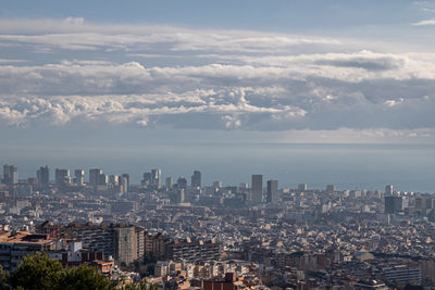 Aerial view of buildings in city against sky
