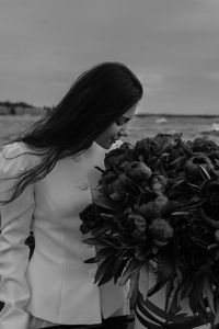 Portrait of young woman standing at beach