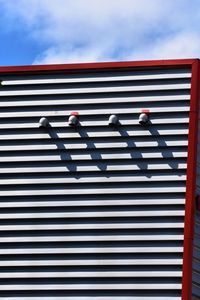 Low angle view of people walking on building against sky