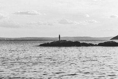 Silhouette man in sea against sky