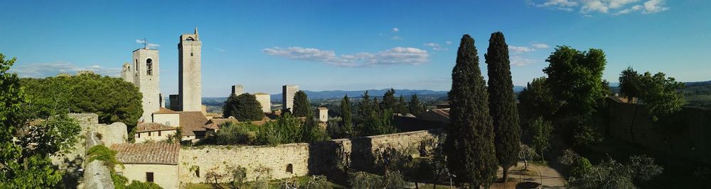 Panoramic view of trees in city against sky