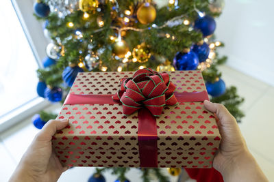 Cropped hand of woman holding christmas presents