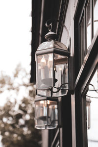 Low angle view of illuminated light bulb hanging from ceiling