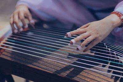 Midsection of woman playing string instrument