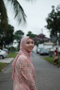 Portrait of smiling young woman standing outdoors