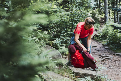 Woman with backpack hiking in mountains, spending summer vacation close to nature