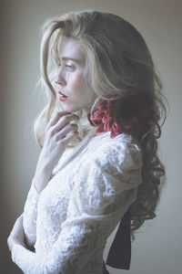 Side view of young woman against gray background