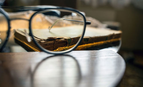 Time and knowledge concept, an eye glasses or spectacles kept in front of a really old torn book