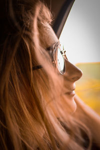 Close-up of young woman looking through car window