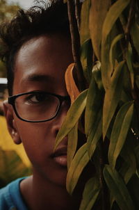 Close-up portrait of man by plant