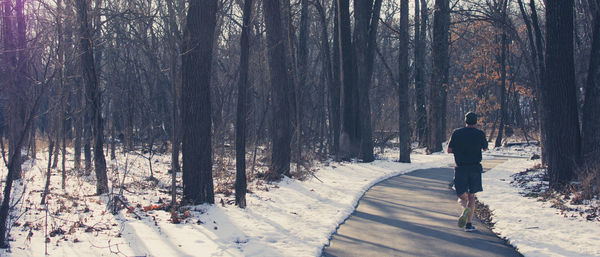 Rear view of woman walking on snow covered land