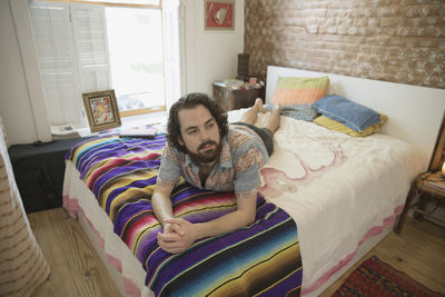 Young man lying on his bed