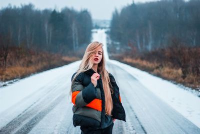 Woman standing on snow covered road