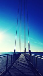 Bridge over sea against blue sky