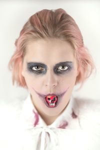Close-up portrait of woman with spooky make-up against white background