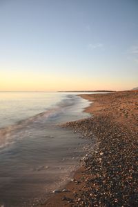 Scenic view of beach against sky during sunset