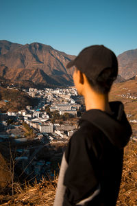 Rear view of man looking at city against sky