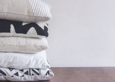 Close-up of white stack on table against wall at home