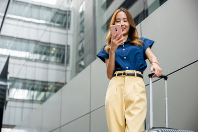 Portrait of young woman standing in city