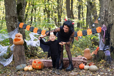 Halloween. mother with little son in halloween costumes having fun outdoor