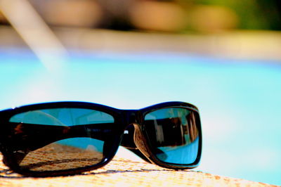 Close-up of sunglasses against blue sky