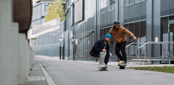 Full length of men skating on street