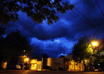 Low angle view of illuminated street lights at night