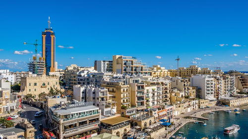 Aerial view of buildings against blue sky