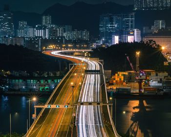 High angle view of illuminated street amidst buildings at night