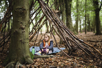 Girl in forest shelter