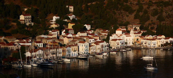 Boats moored in river by buildings in town