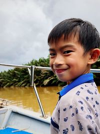 Portrait of happy boy on boat in lake