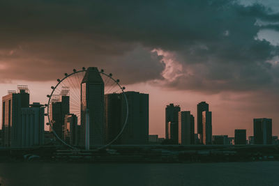 Modern buildings in city against sky during sunset