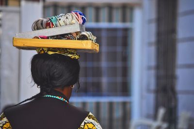 Rear view of woman carrying ornaments on head