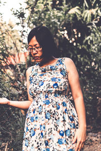 Woman standing against trees