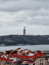 Buildings by sea against sky