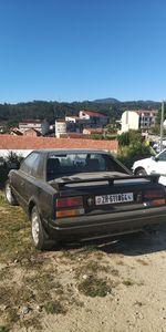 Car on field against clear blue sky