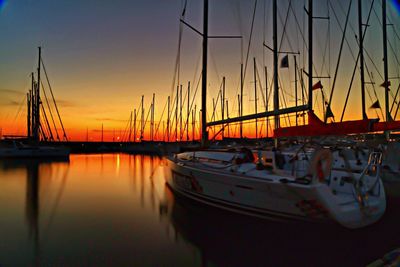 Sailboats moored at harbor