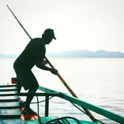 Man standing on sea against clear sky