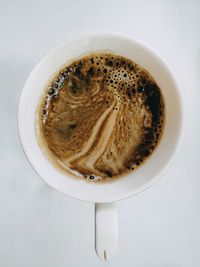 Coffee with foam poured into a white mug