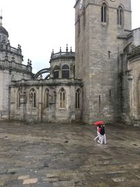 Full length of woman on historic building against sky