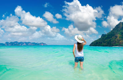 Full length of woman standing on sea shore against sky