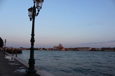 Lamp post on footpath by grand canal at dusk