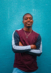 Portrait of young man standing against wall