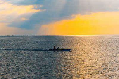 People on boat against sky during sunset