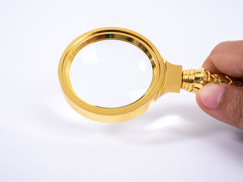 Close-up of hand holding glass against white background