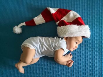 Directly above shot of child wearing santa hat on rug